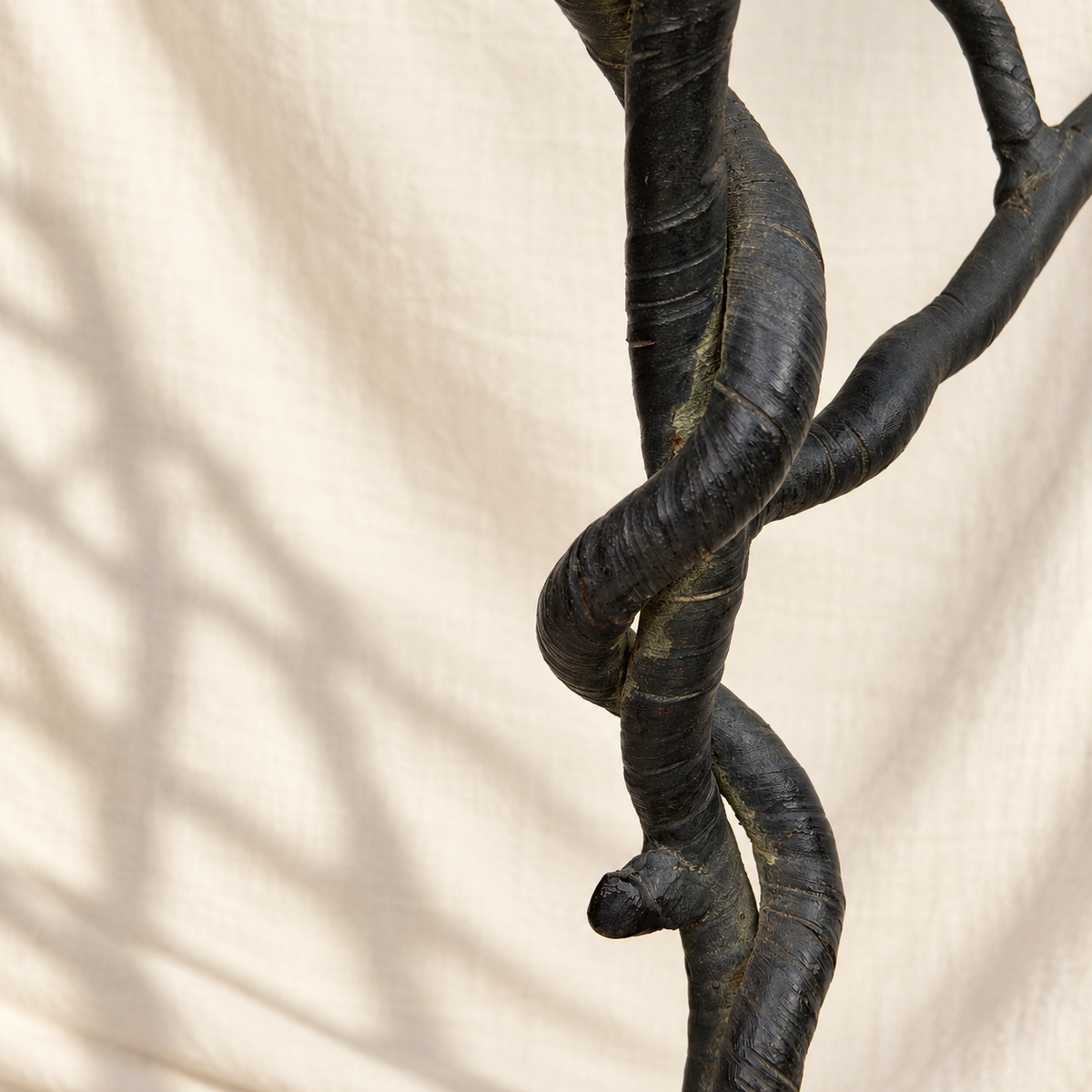 Close-up of twisted metal trunk on sculptural tree-form floor stand