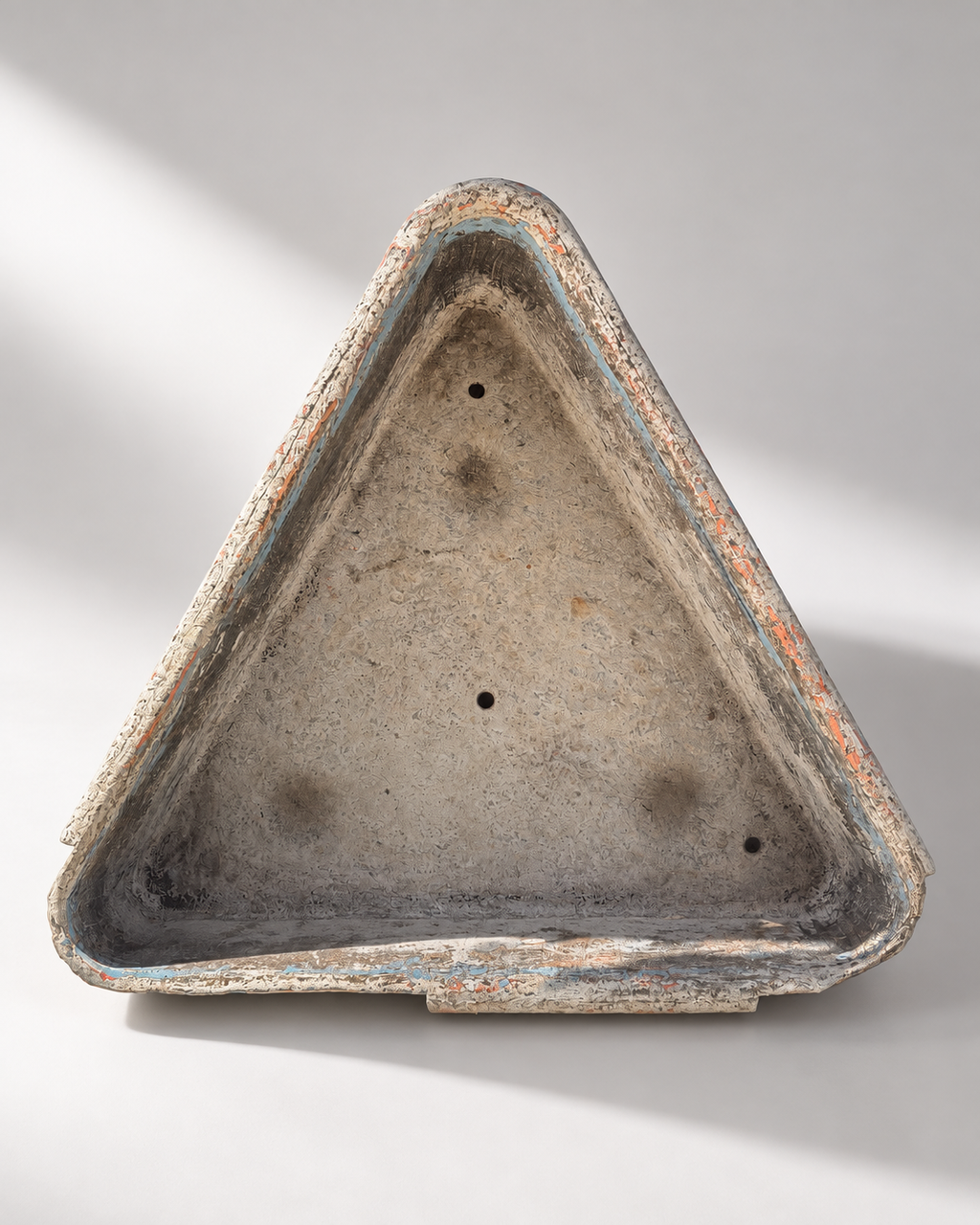 Interior of triangular garden planter showing the opening and worn finish