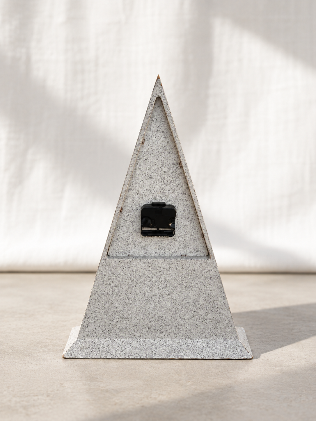 Side view of triangular table clock with speckled finish