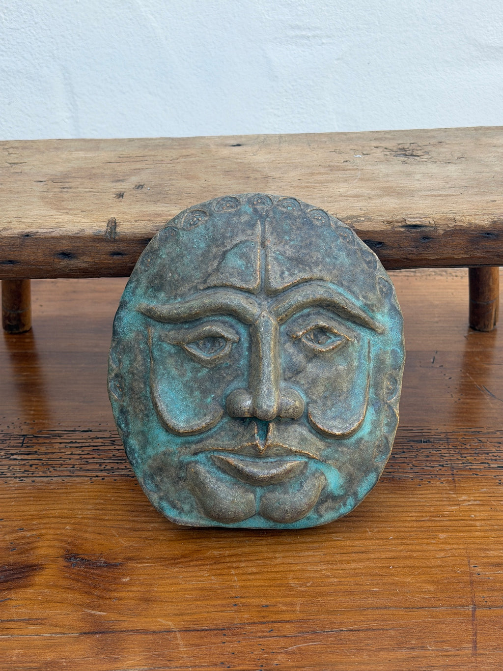 Detail of blue-green finish on sculptural face wall plaque