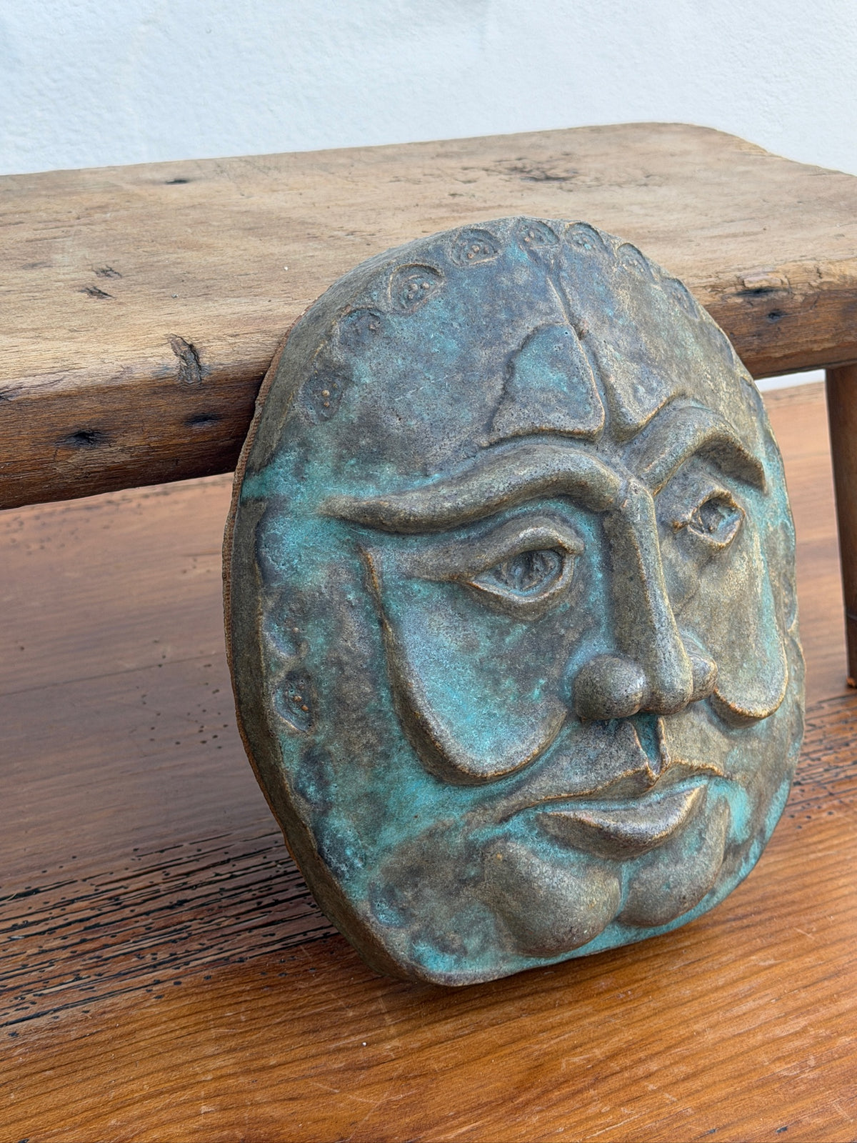 Expressive face wall sculpture with verdigris-style finish