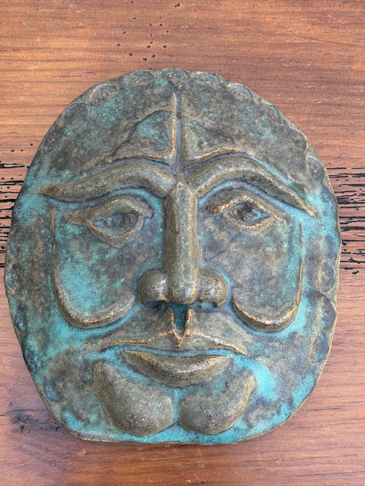 Expressive face wall sculpture with verdigris-style finish