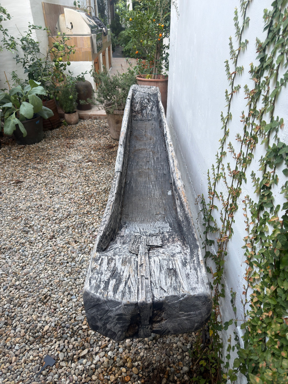 Rustic antique wood trough used as a large garden planter