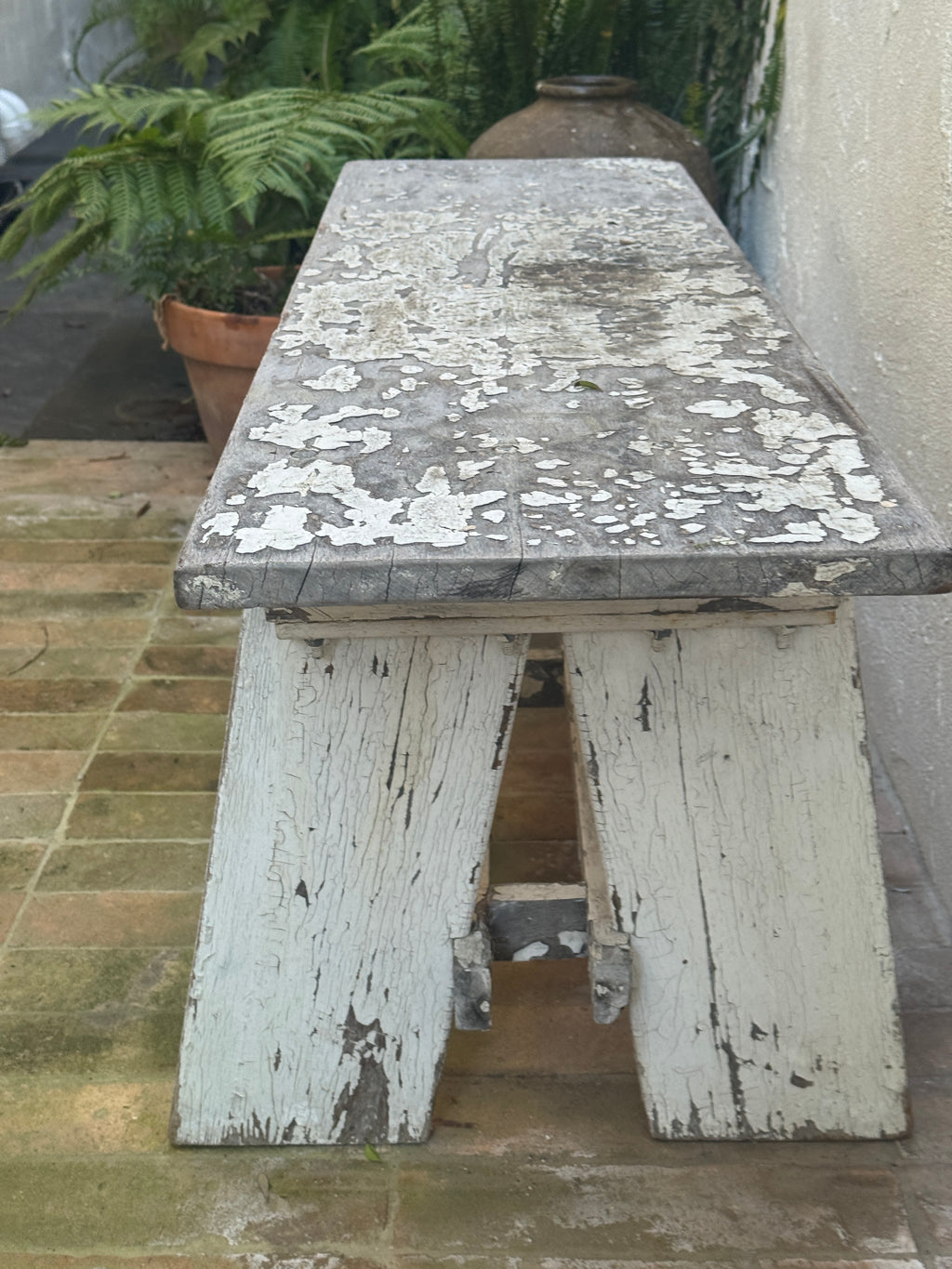 Weathered painted wood garden bench with thick plank seat