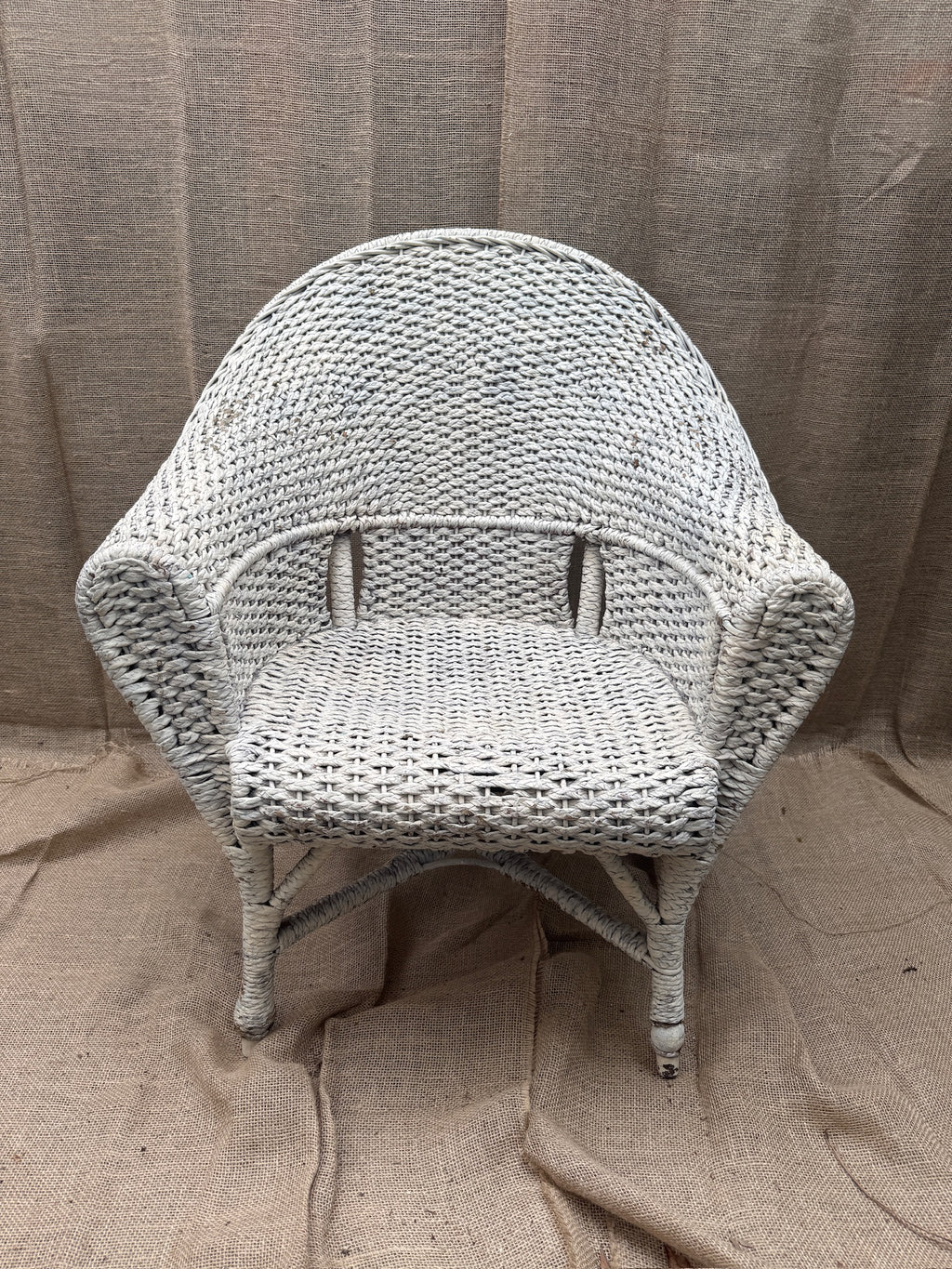Vintage white wicker armchair with barrel-back design