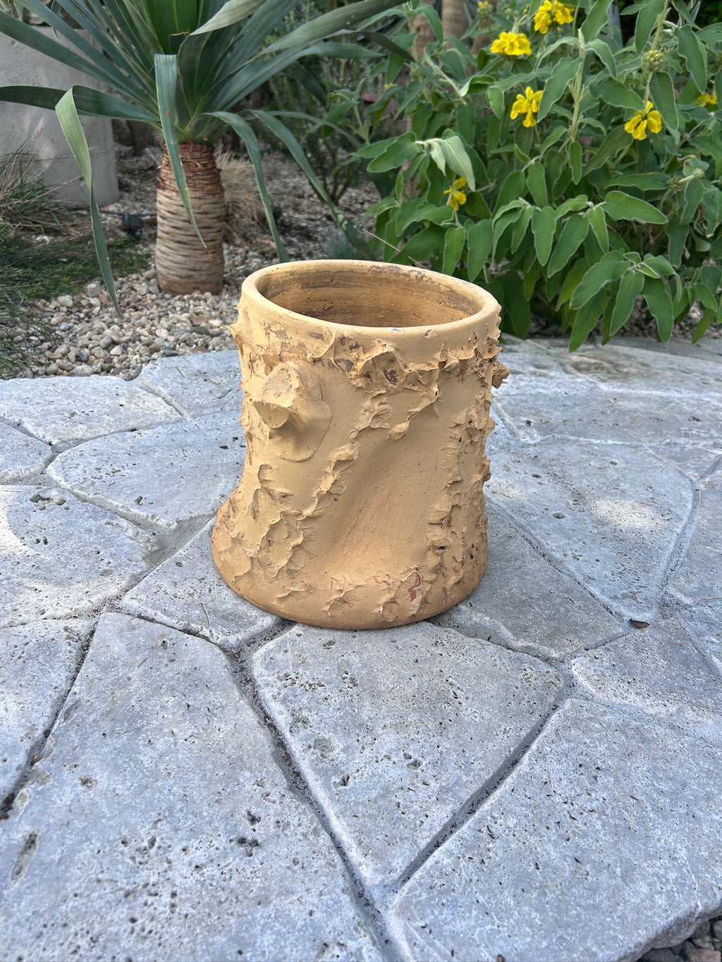 Rustic terracotta garden pot with textured tree-bark surface