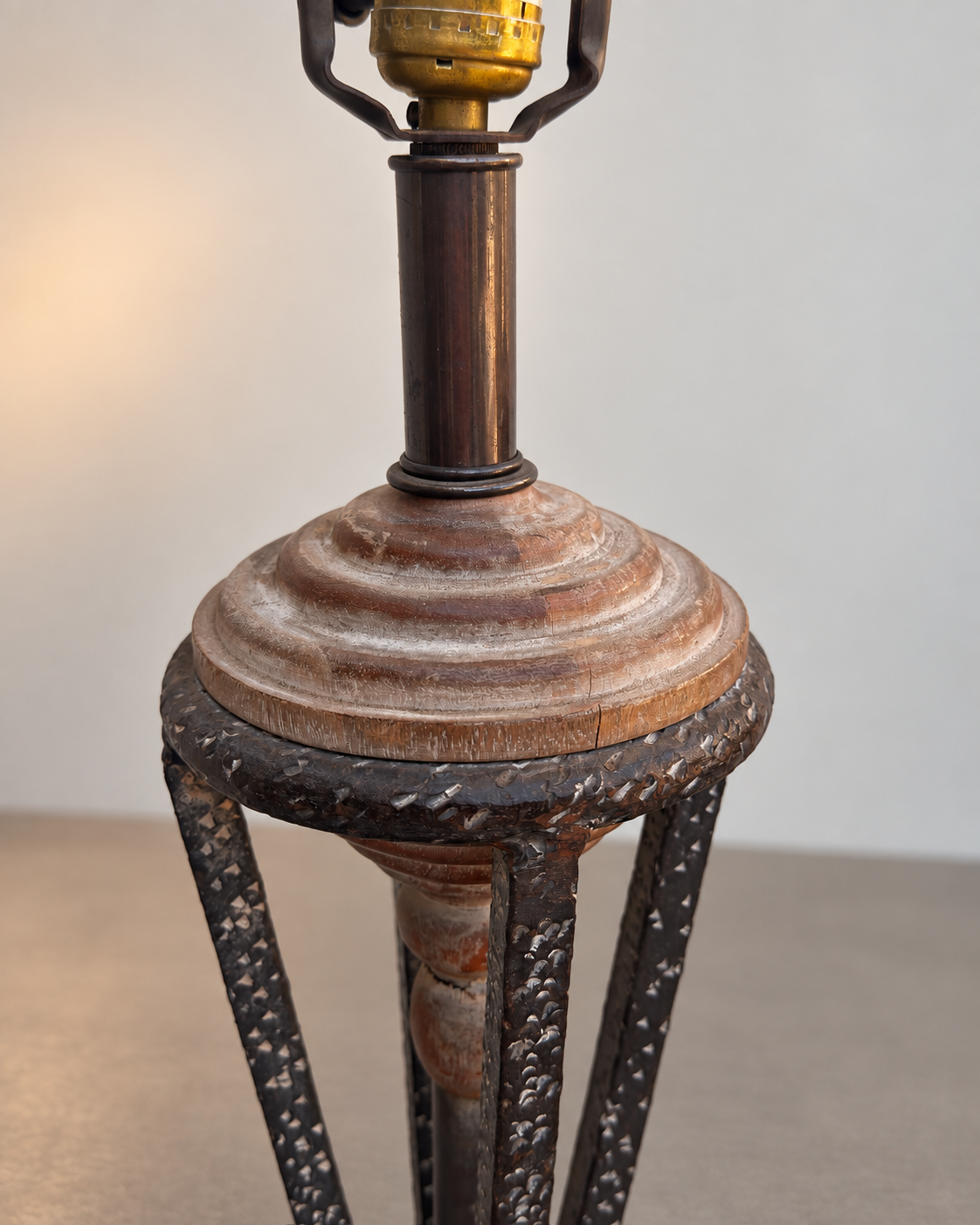 Sculptural table lamp with dark metal frame and natural wood details