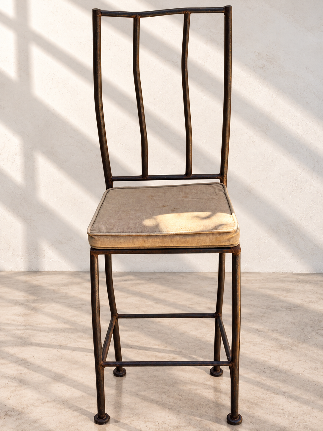 Sculptural black iron bar stools with tall open backs