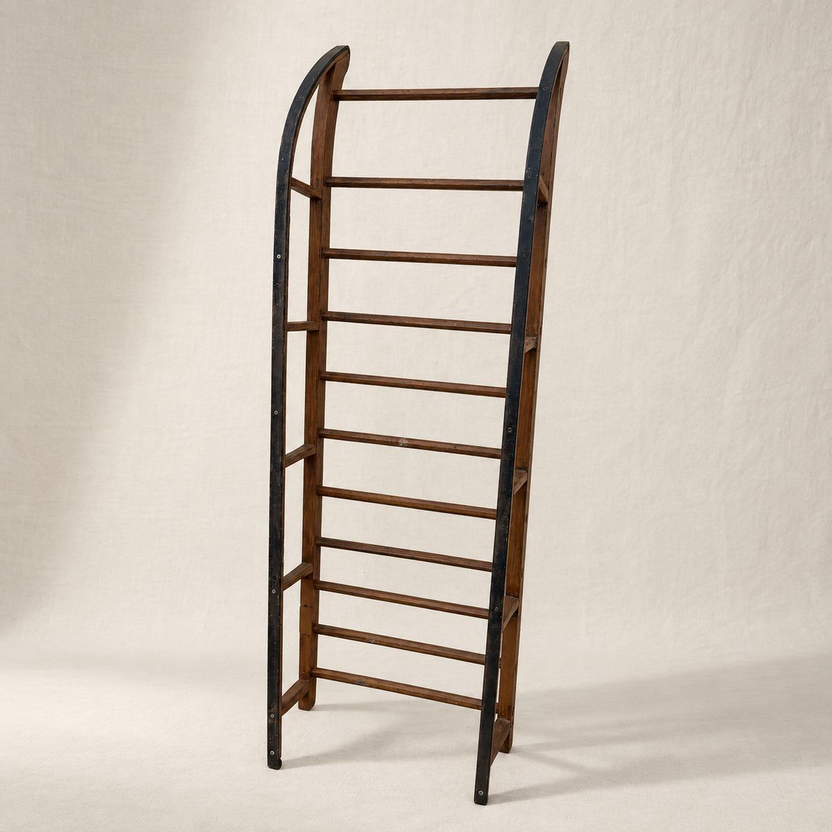 Primitive wood sled with open ladder frame and iron-shod runners