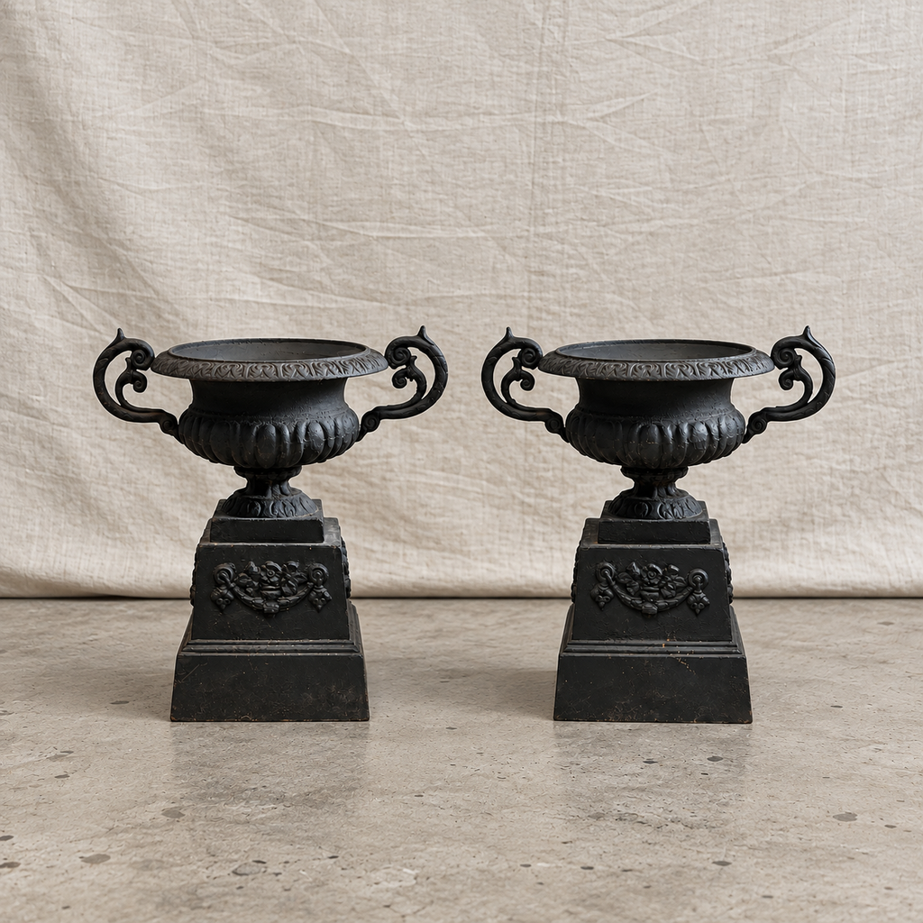 Pair of 19th-century Neoclassical black cast iron garden urns with C-scroll handles, weathered patina and matching plinth bases — Hommes and Gardens, Pots + Planters Collection, Objects + Curiosities Collection, Home Decor, Landscape Architect, Interior Designer, Outdoor Living, Outdoor Decorations, Garden Design, Home Design, Luxury Design, Art, Furniture, Objects, Best Gifts, Nature, Backyard, Yard.