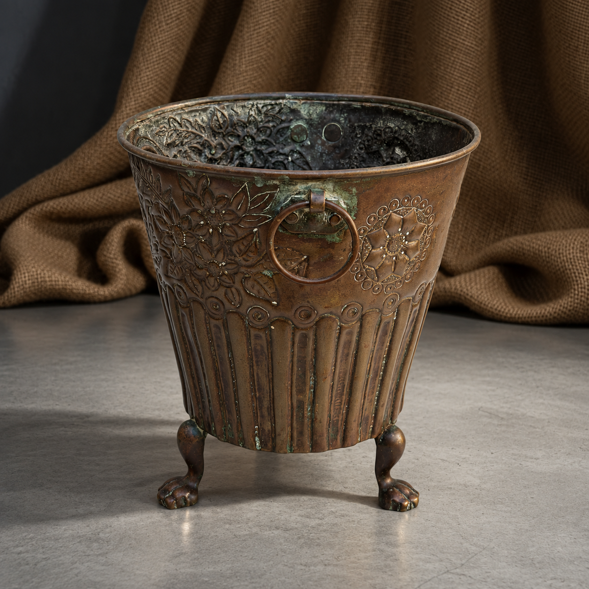 Brass cachepot with floral decoration, a monogram and paw-shaped feet.