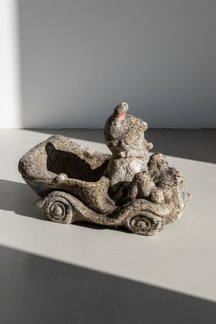 1960s concrete garden gnome driving a wheelbarrow planter with rustic pebble-textured finish, a whimsical vintage outdoor garden ornament — Hommes and Gardens, Fauna Collection, Pots + Planters Collection, Objects + Curiosities Collection, Home Decor, Landscape Architect, Interior Designer, Outdoor Living, Outdoor Decorations, Garden Design, Home Design, Luxury Design, Art, Furniture, Objects, Best Gifts, Nature, Backyard, Yard.