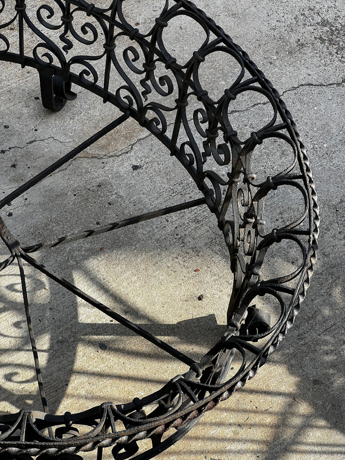 Victorian Oval Wrought Iron Plant Holder showcasing intricate scrollwork and dark patina. hommes + gardens estudio.