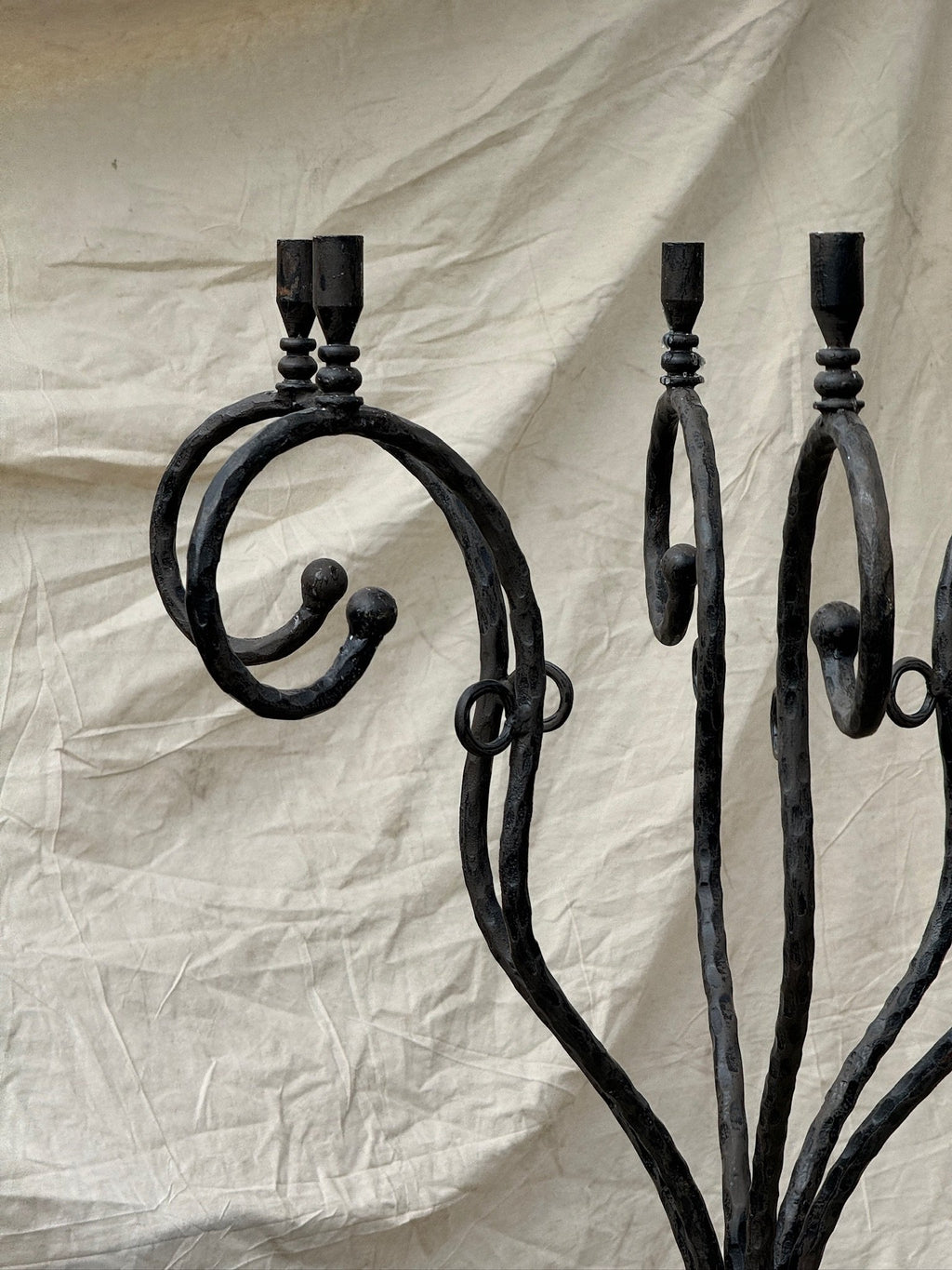 Vintage Scrolled Cast Iron Candelabrum with intricate scrolled arms against a neutral backdrop, hommes + gardens estudio.