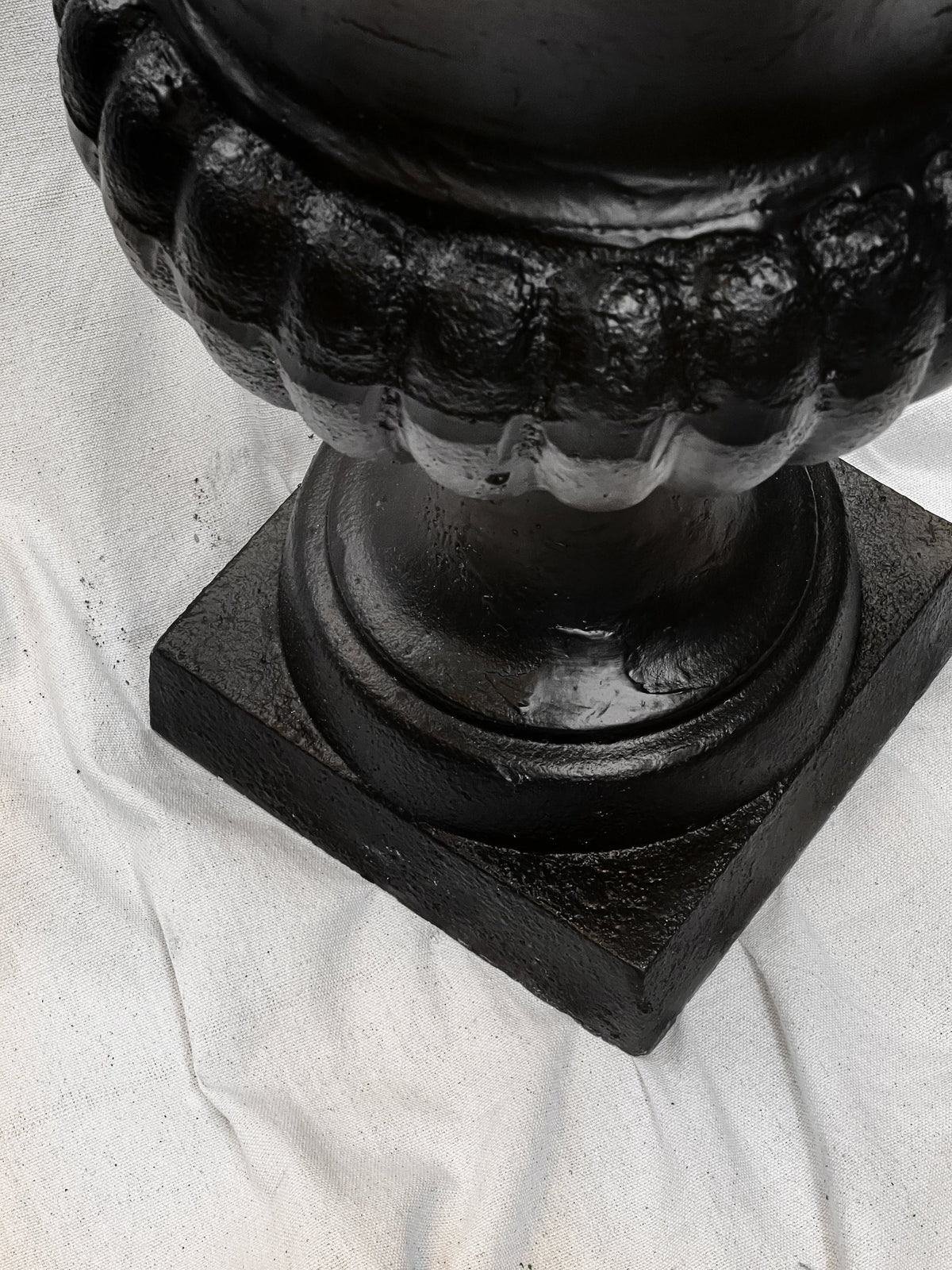 Close-up of the base of a Pair of 29" French Cast Iron Urn Black Planters showcasing its elegant details. hommes + gardens estudio.