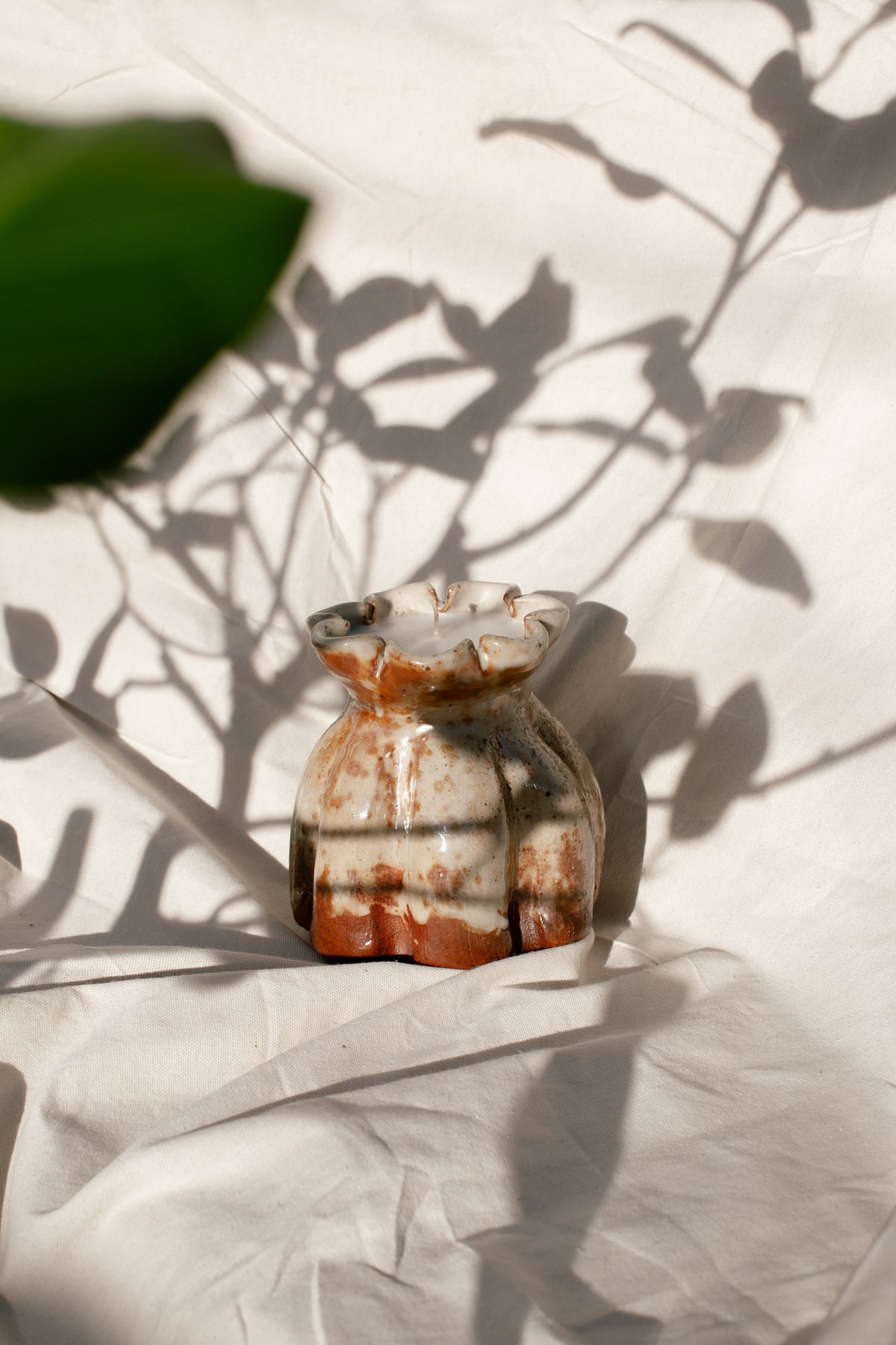 Ceramic Lotus Vase- H&G x Western Disco Candle Collaboration displayed on a textured surface with plant shadow, hommes + gardens estudio.