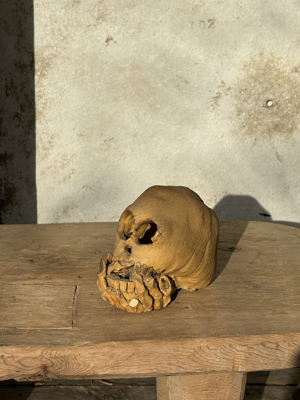 Handcrafted ceramic skull candle holder featuring artistic clasped hand details, ideal for unique and bold home styling — Hommes and Gardens, home decor, outdoor decorations, home design, luxury design, Landscape Architect, Interior Designer, Outdoor Living, Art, Furniture, Objects, Best Gifts, Nature, Backyard, Yard.