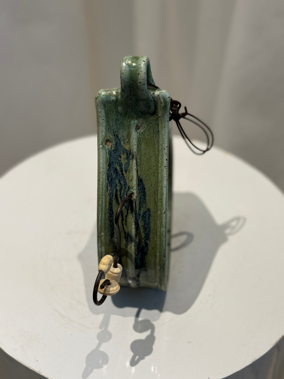 Handcrafted J.S. ceramic hanging wall decor vessel with curved body and green glaze finish, ideal as a wall-mounted accent or incense holder — Hommes and Gardens, Objects Collection, Landscape Architect, Interior Designer, Outdoor Living, Art, Furniture, Objects, Best Gifts, Nature, Backyard, Yard, Outdoor Decorations, Home Decor, Home Design, Luxury Design.