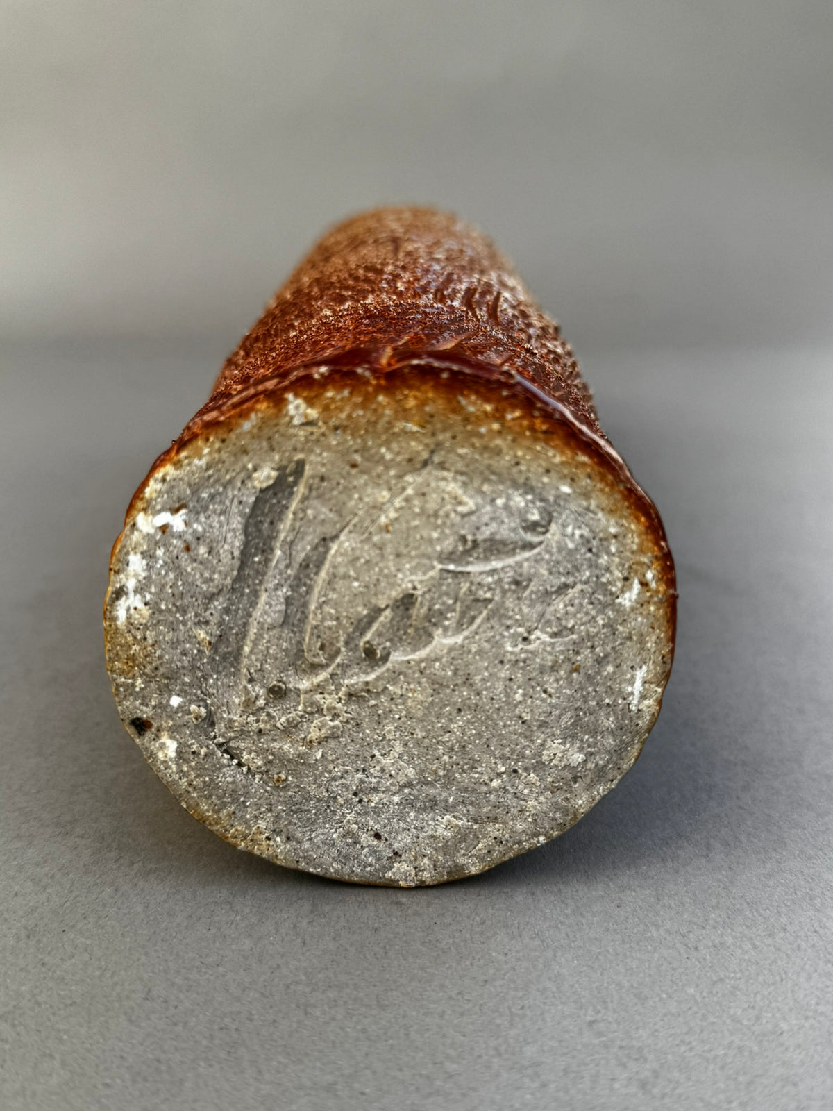 Base of tall textured studio pottery vase with glazed rim – signed ceramic art piece by hommes + gardens estudio.