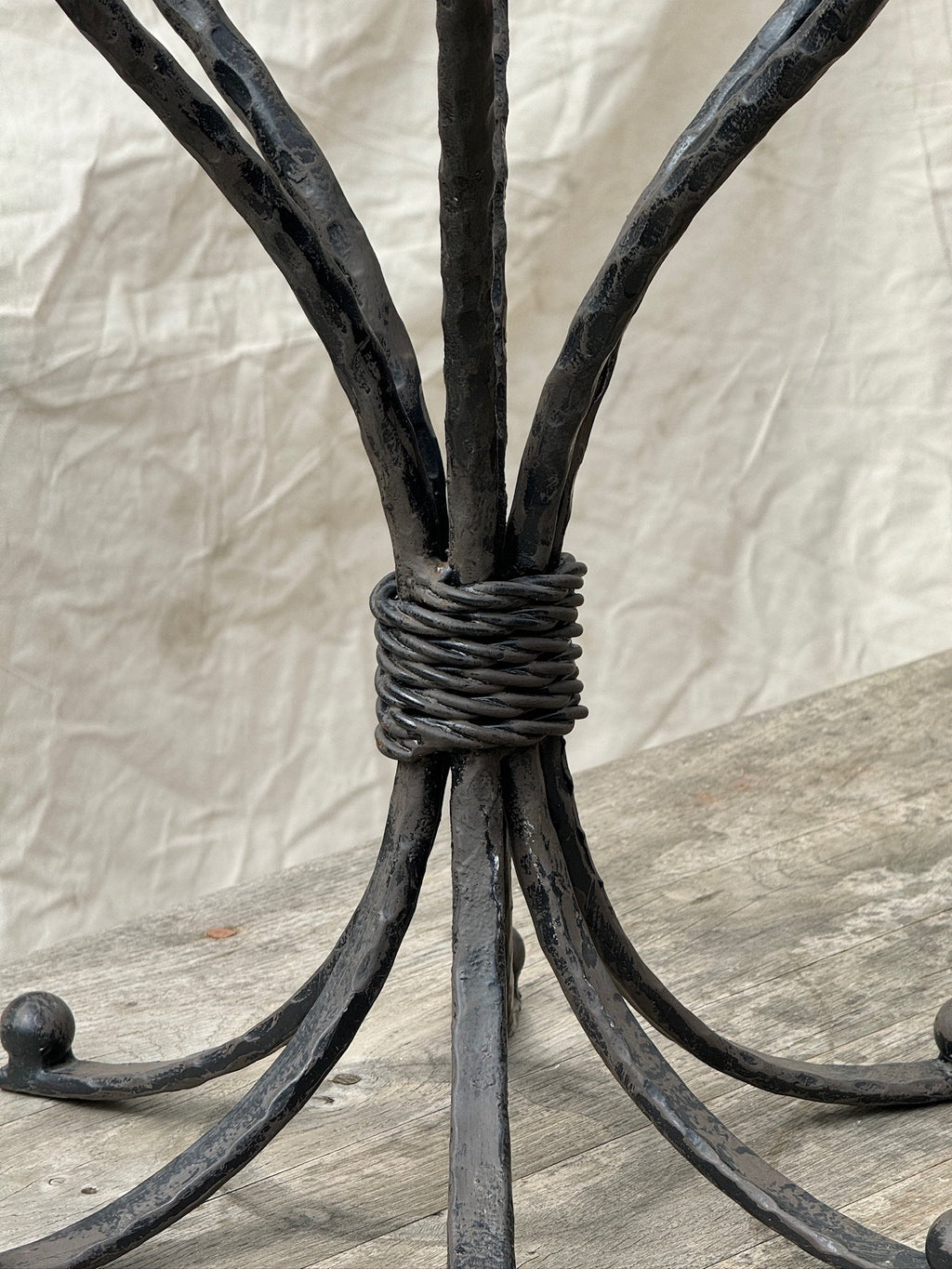 Close-up of the intricate design of the Vintage Scrolled Cast Iron Candelabrum showcasing its elegant scrolled base. hommes + gardens estudio