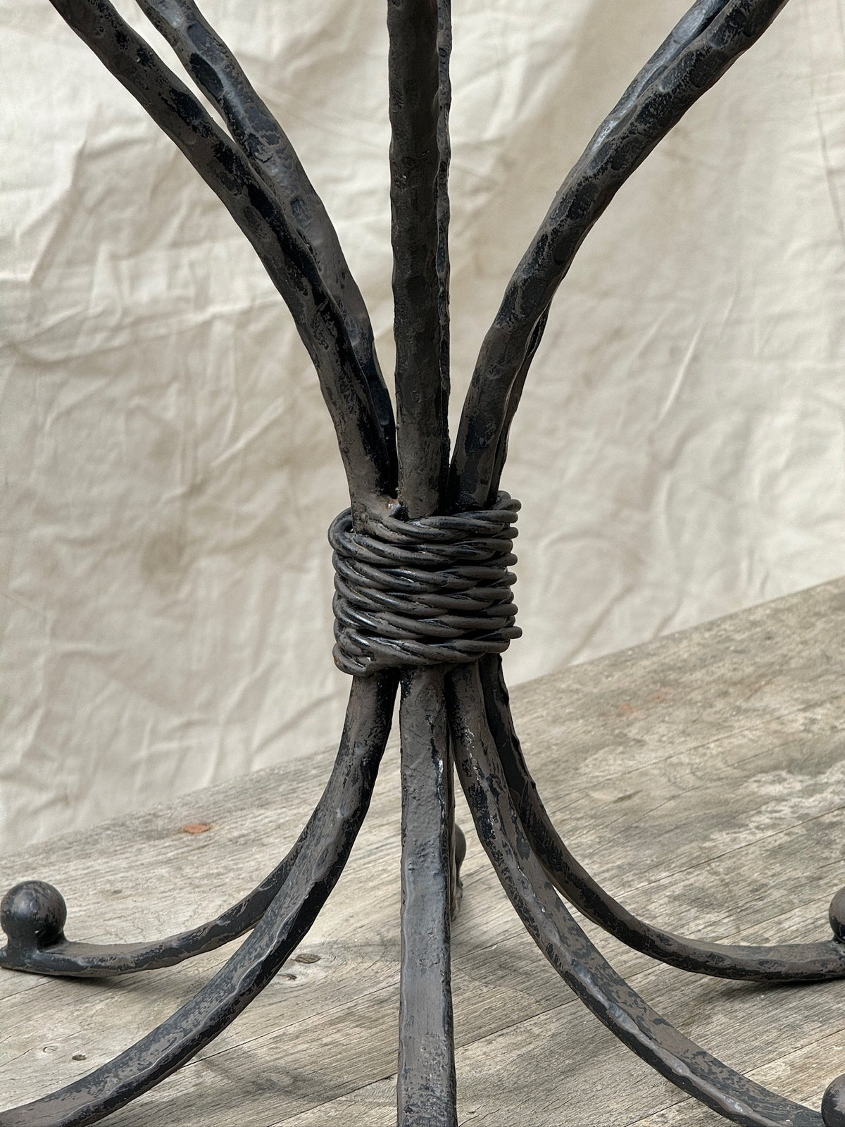 Close-up of the intricate design of the Vintage Scrolled Cast Iron Candelabrum showcasing its elegant scrolled base. hommes + gardens estudio